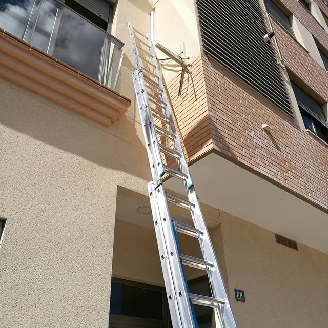 Instalación de una antena de televisión en la fachada de un edificio con escalera