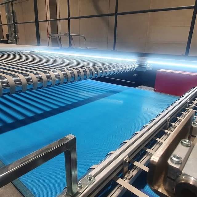 Iluminación LED lineal instalada sobre maquinaria en una nave industrial